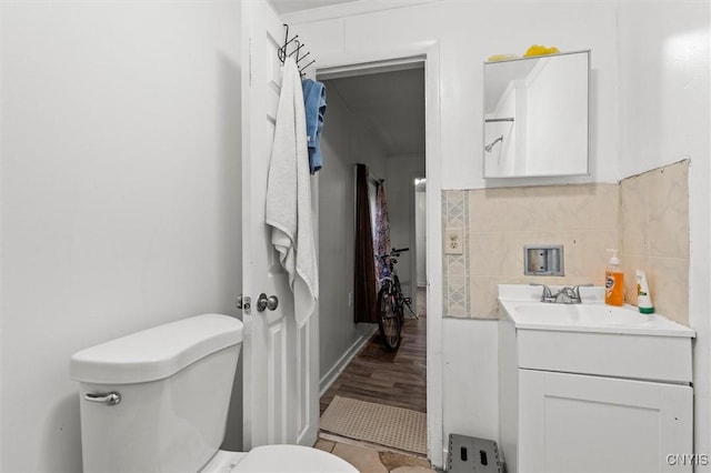 bathroom with toilet, vanity, and tasteful backsplash