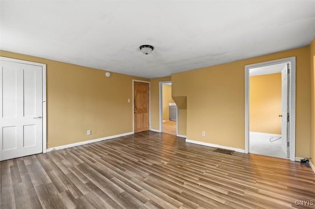 unfurnished bedroom with ensuite bath and hardwood / wood-style flooring