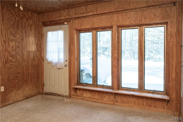 entryway with light carpet and wooden walls