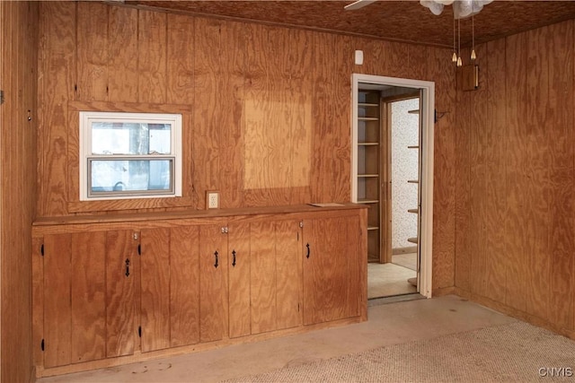 misc room with ceiling fan and wood walls