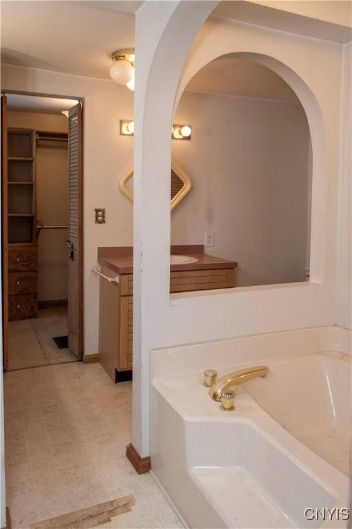 bathroom with vanity and a tub