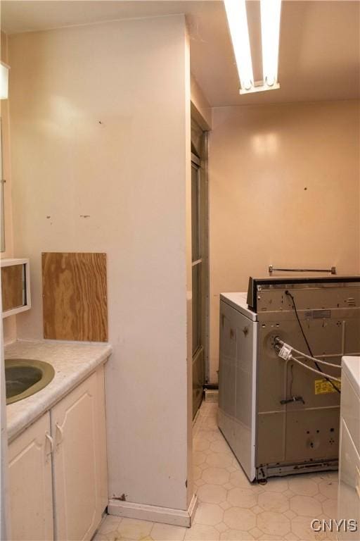 laundry room with cabinets, sink, and washer / dryer