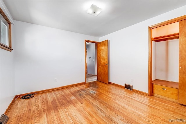 unfurnished bedroom featuring a closet and light hardwood / wood-style floors