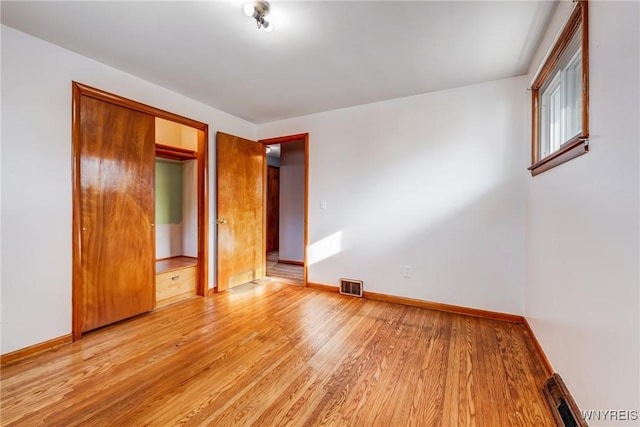 unfurnished bedroom featuring a closet and light hardwood / wood-style floors