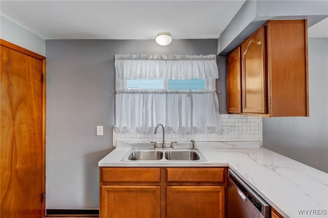 kitchen with light stone countertops, dishwasher, tasteful backsplash, and sink