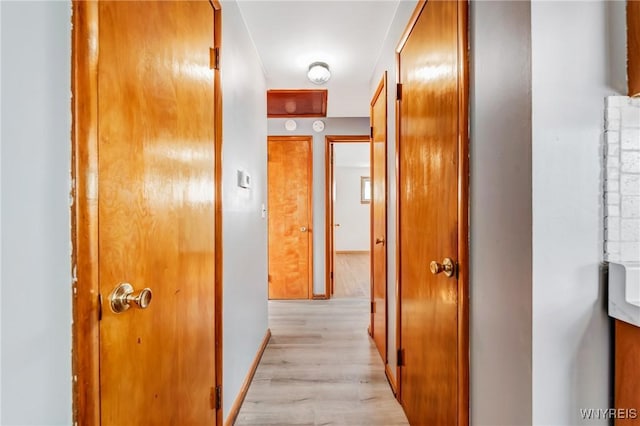 hallway with light hardwood / wood-style floors