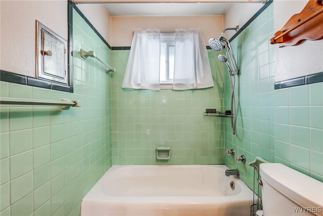 bathroom featuring toilet and tiled shower / bath