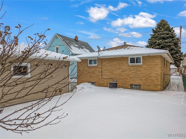 snow covered house with central air condition unit