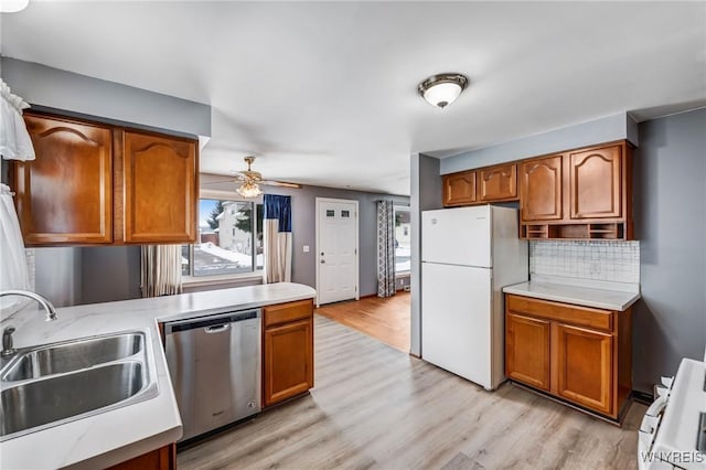 kitchen with dishwasher, white refrigerator, tasteful backsplash, sink, and ceiling fan