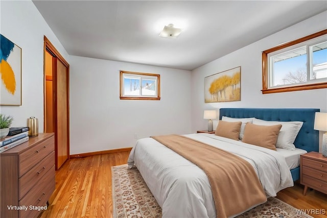 bedroom with light hardwood / wood-style floors and a closet