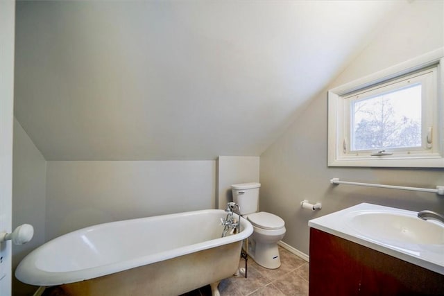 bathroom with lofted ceiling, vanity, toilet, and a tub to relax in