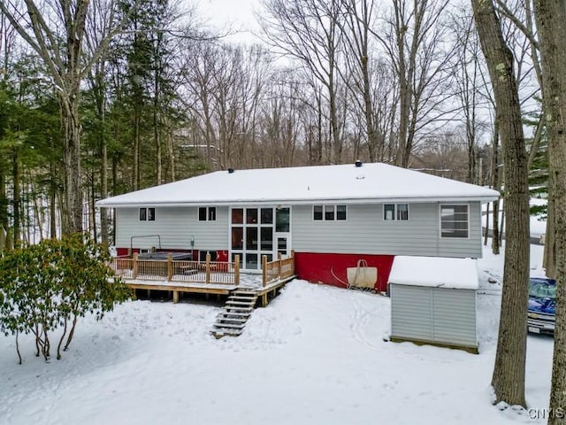 snow covered house featuring a deck