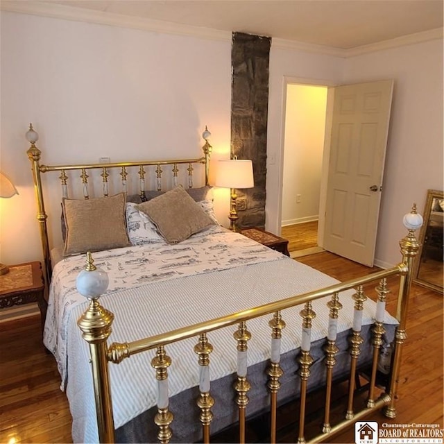 bedroom with ornamental molding and hardwood / wood-style floors