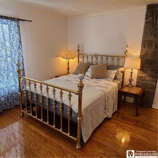 bedroom featuring ornamental molding and hardwood / wood-style floors