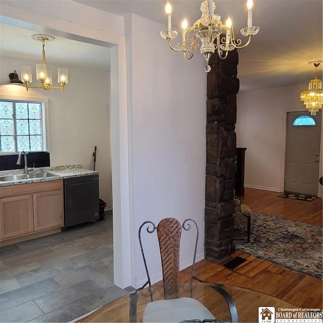 dining room with a notable chandelier, light hardwood / wood-style flooring, and sink