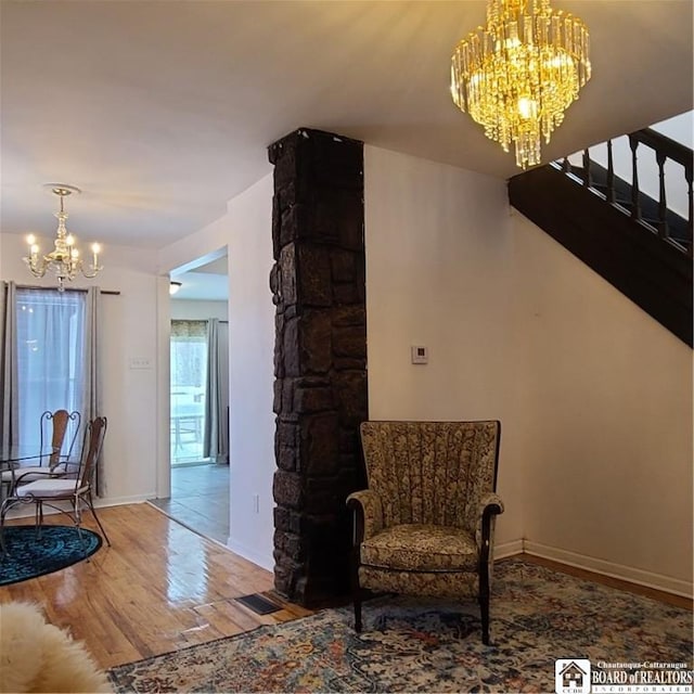 living area featuring hardwood / wood-style floors and an inviting chandelier