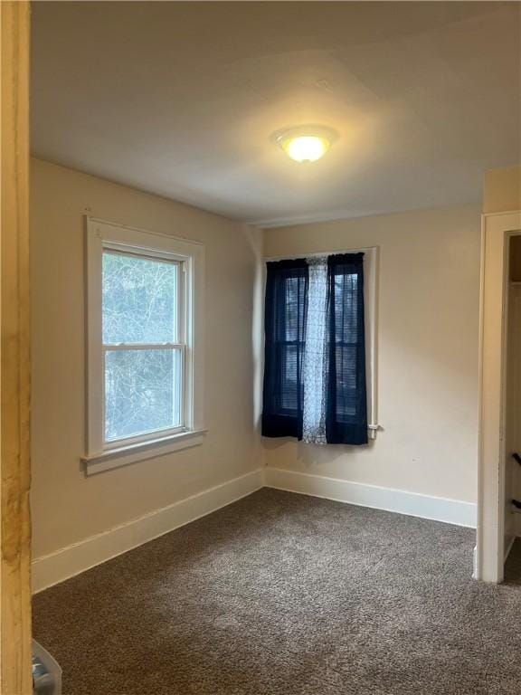 empty room with dark colored carpet