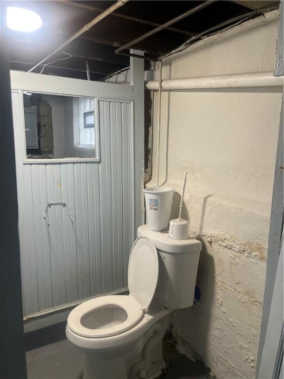 bathroom featuring toilet and electric panel