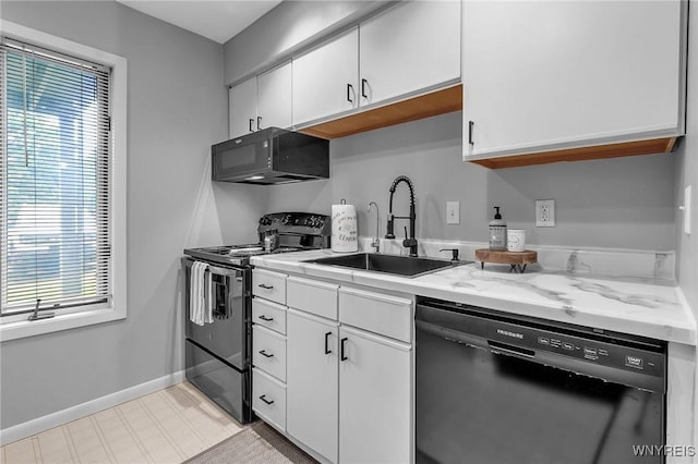 kitchen featuring light stone countertops, sink, white cabinets, and black appliances