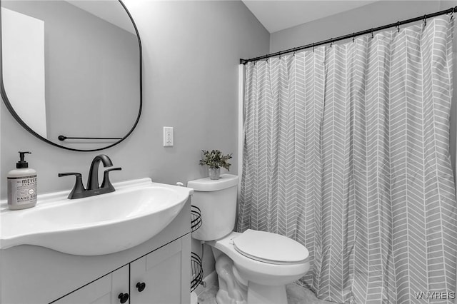 bathroom featuring toilet, vanity, and walk in shower