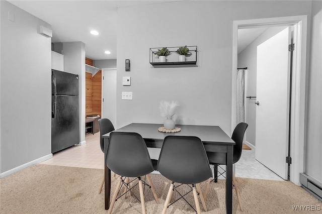 dining room with baseboard heating and light carpet