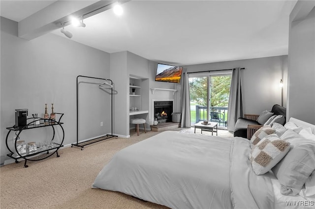 bedroom with access to outside, beamed ceiling, and carpet flooring