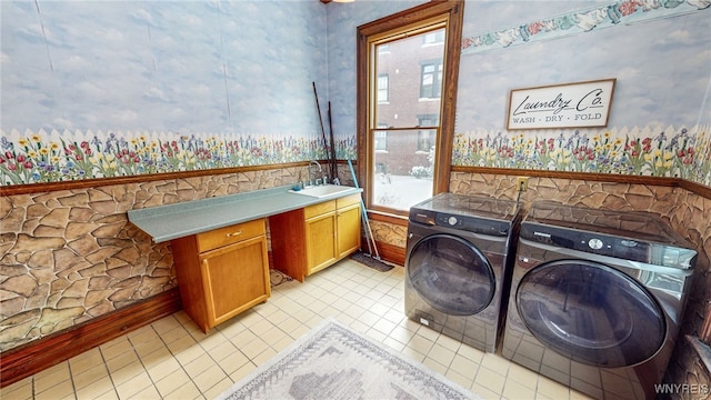 washroom with washing machine and dryer, light tile patterned flooring, wet bar, and cabinets