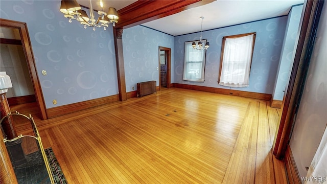 unfurnished dining area with radiator, a chandelier, and hardwood / wood-style floors