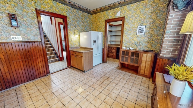 kitchen featuring white fridge with ice dispenser and light tile patterned floors