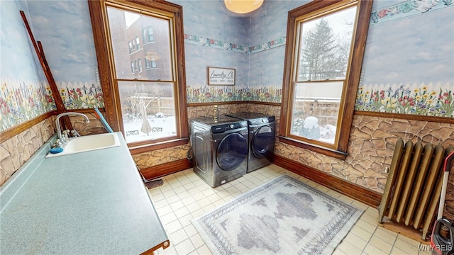 clothes washing area with sink, light tile patterned floors, radiator heating unit, and independent washer and dryer