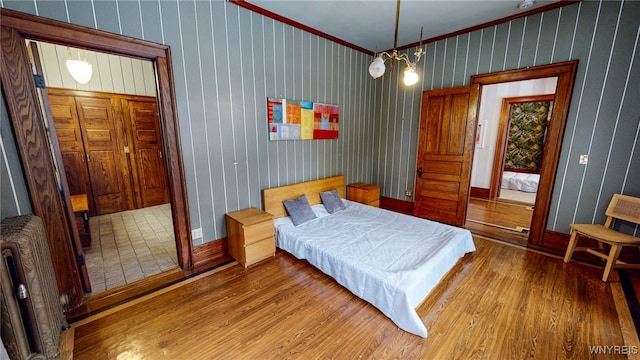 bedroom featuring radiator, ornamental molding, and hardwood / wood-style flooring