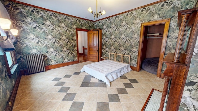 bedroom featuring radiator, a closet, crown molding, and decorative columns