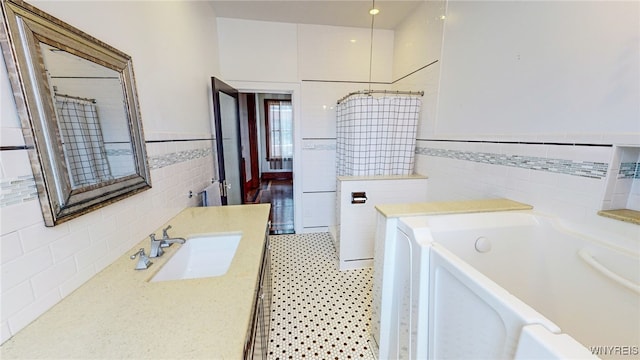 bathroom featuring a tub, tile walls, and vanity