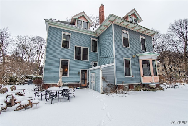 view of snow covered back of property