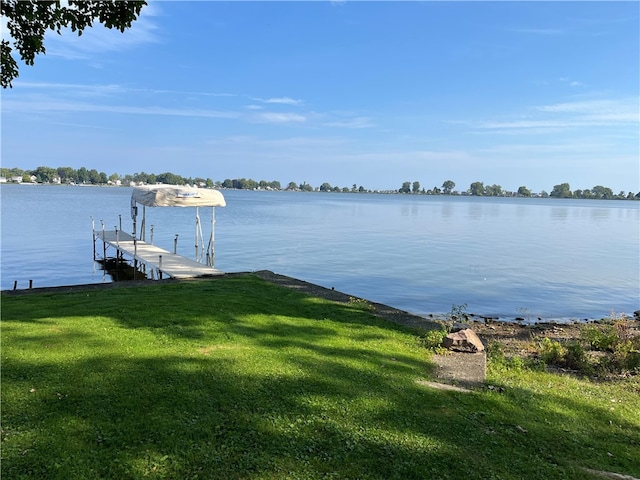 dock area with a water view and a lawn