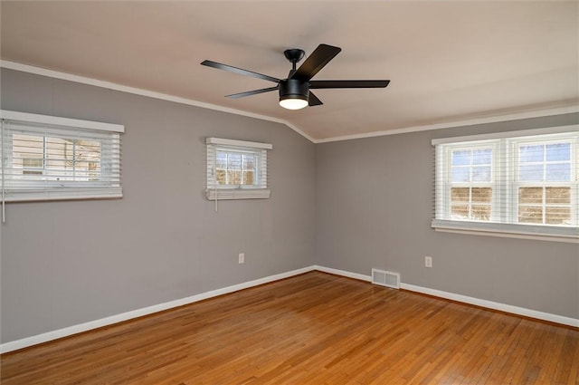 empty room with ceiling fan, ornamental molding, a healthy amount of sunlight, and hardwood / wood-style flooring