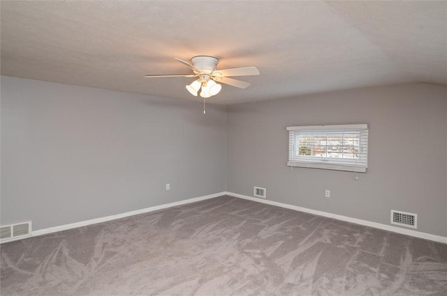 unfurnished room with ceiling fan, vaulted ceiling, and dark carpet