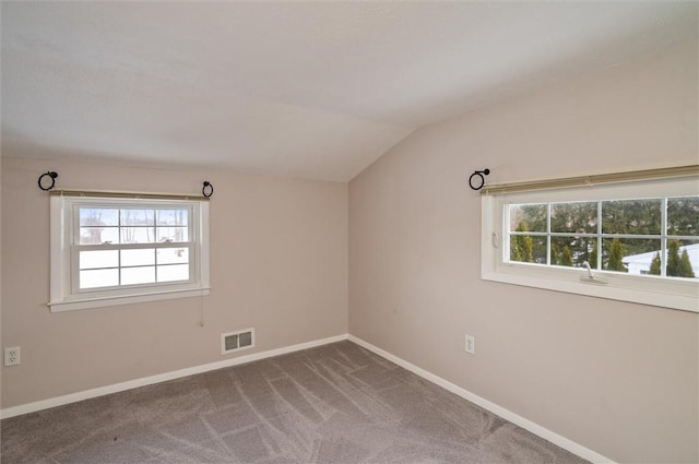 carpeted spare room featuring lofted ceiling