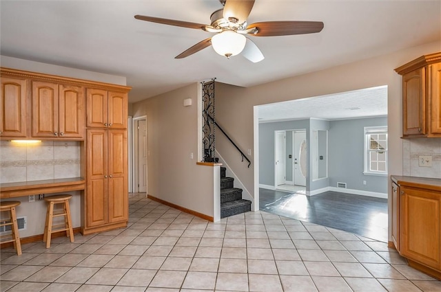 kitchen with ceiling fan, decorative backsplash, light tile patterned flooring, and tile countertops