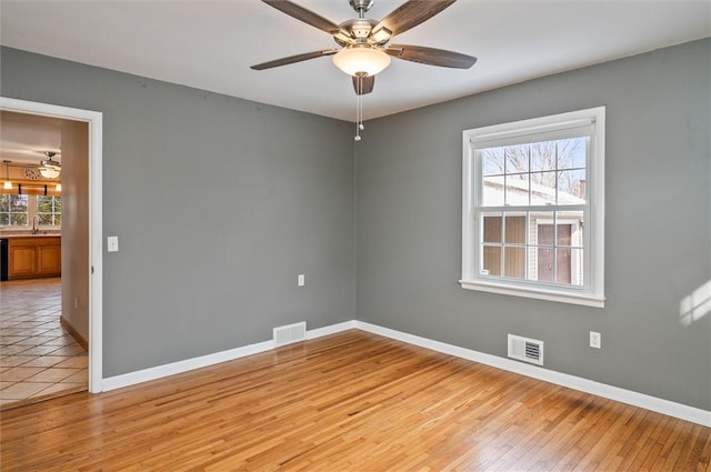 empty room featuring light wood-type flooring and ceiling fan