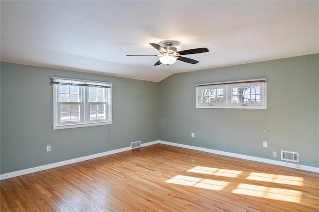 empty room featuring vaulted ceiling, ceiling fan, and hardwood / wood-style flooring