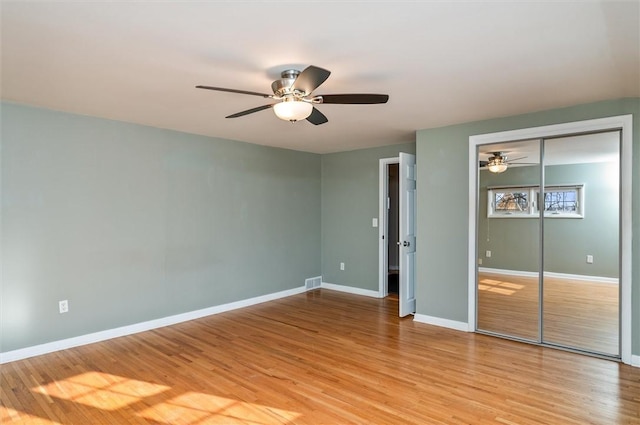 unfurnished bedroom with ceiling fan, light hardwood / wood-style flooring, and a closet