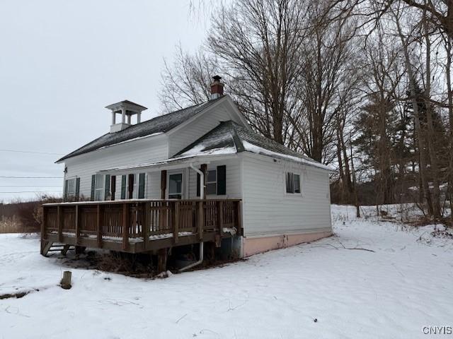 snow covered house with a wooden deck