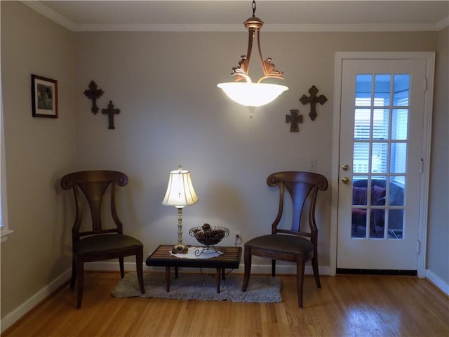 sitting room with wood-type flooring and crown molding