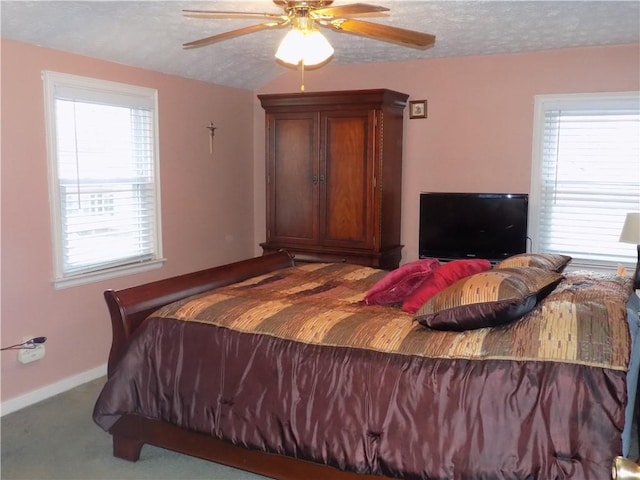 bedroom with light carpet, ceiling fan, a textured ceiling, and multiple windows