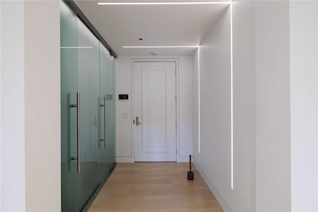 hallway with light hardwood / wood-style flooring