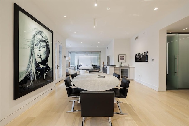 dining room with wine cooler and light hardwood / wood-style flooring