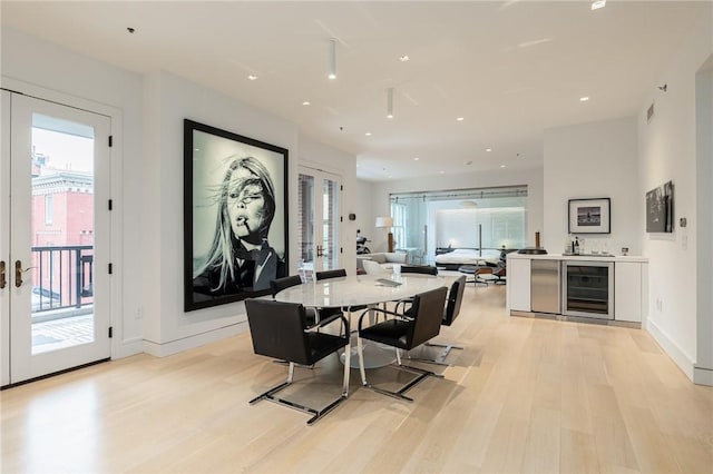 dining room featuring light hardwood / wood-style flooring, french doors, and wine cooler