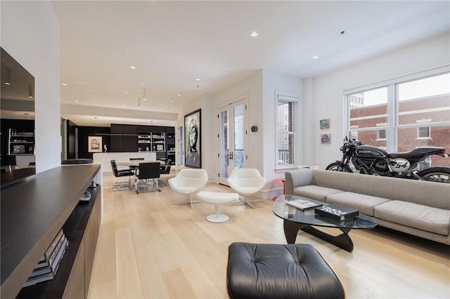 living room with light wood-type flooring and french doors