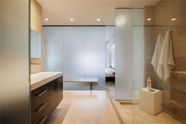 bathroom featuring walk in shower, vanity, and tile patterned flooring